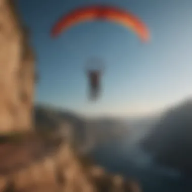 Silhouetted figure leaping off a cliff with a parachute