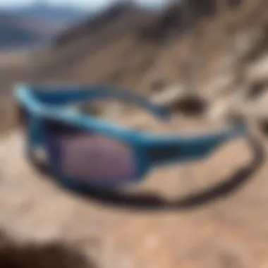 Blue pit viper sunglasses with reflective lenses on a rocky mountain peak