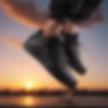 Black leather Nike shoe in mid-air jump against a vibrant sunset background