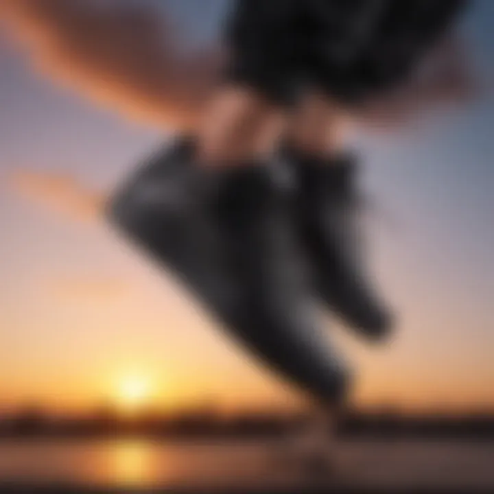 Black leather Nike shoe in mid-air jump against a vibrant sunset background