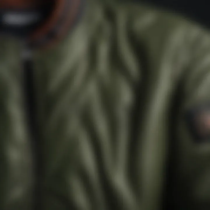 Close-up of the fabric texture and detailing of an army green bomber jacket.