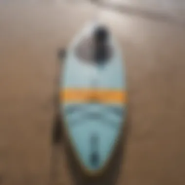 Close-up of a stand-up paddle board on the sandy shoreline