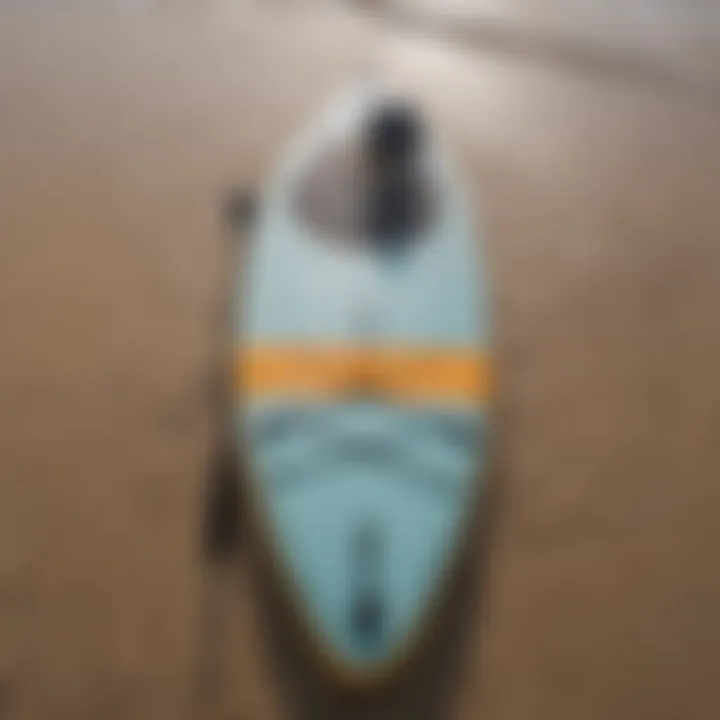 Close-up of a stand-up paddle board on the sandy shoreline