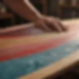 Craftsman meticulously sanding surfboard