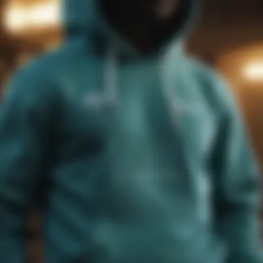 Elegant teal hoodie hanging on display