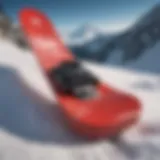 A sleek red snowboard resting against a snowy backdrop