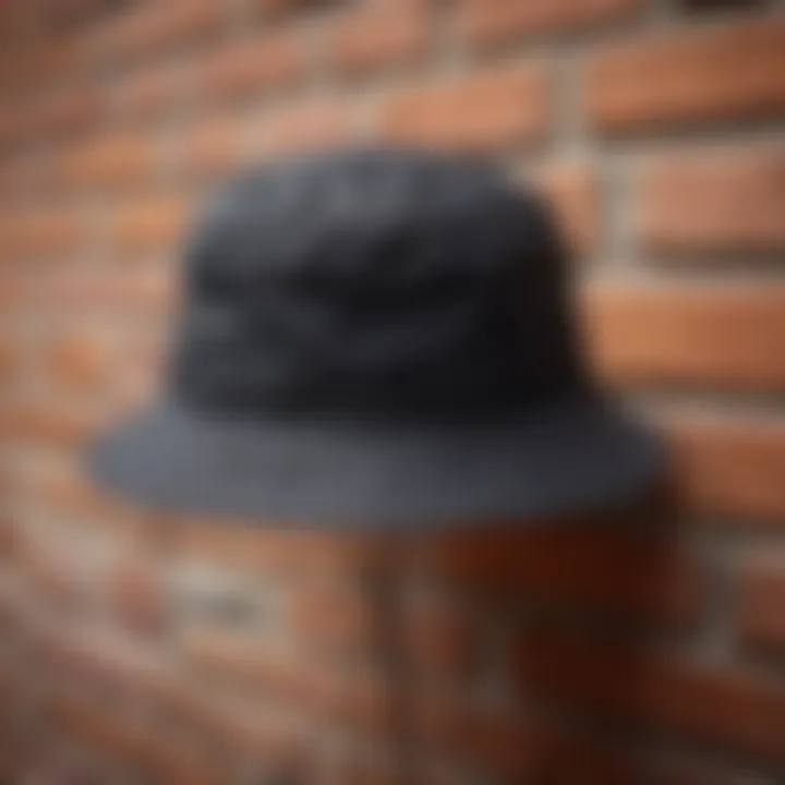 Close-up of textured fabric of black bucket hat against brick wall